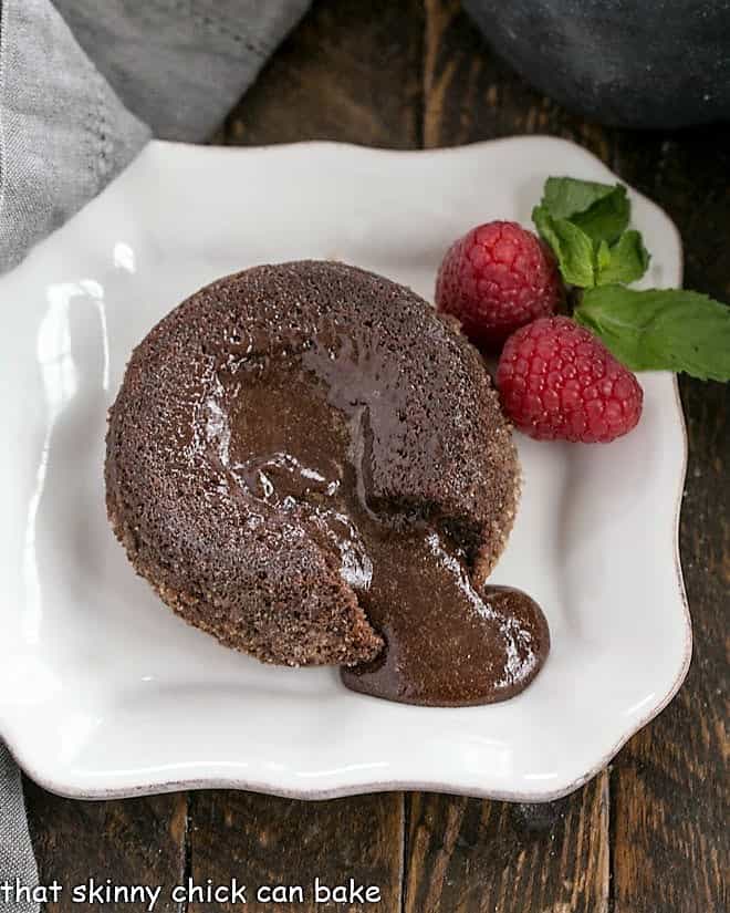 A molten lava cake with a forkful of cake on a white plate