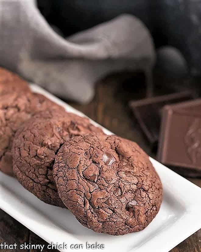 Black Gold Cookies lined up on a white rectangular tray