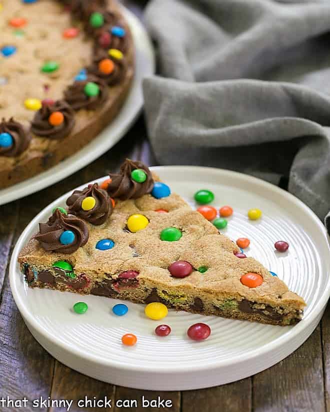 Wedge of chocolate chip cookie cake on a white plate.