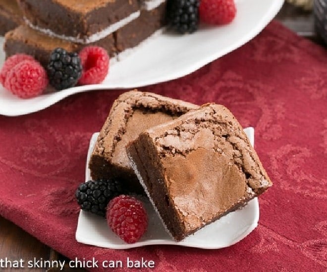 One Bowl Fudgy Brownies on a small white wavy plate with berries.