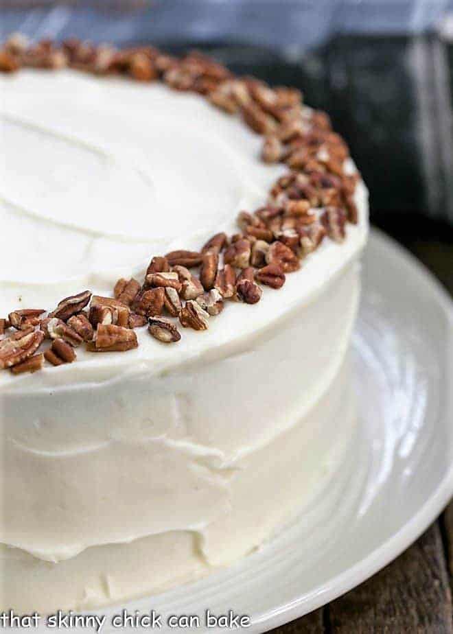 Partial view of whole cheesecake stuffed carrot cake with cream cheese frosting