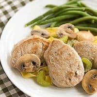 Easy Pork Scaloppine on a white plate with green beans