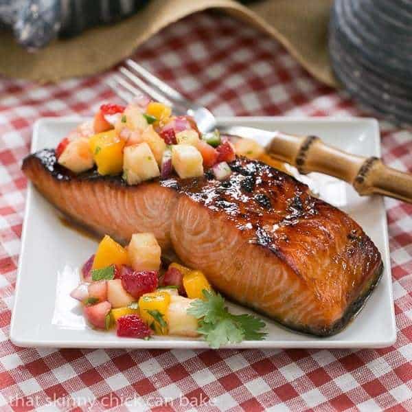 Maple Glazed Salmon on a square white plate topped with fruit salsa.