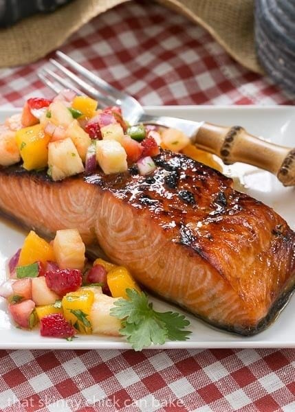 Maple Glazed Salmon on a square white plate on a red and white checked napkin.
