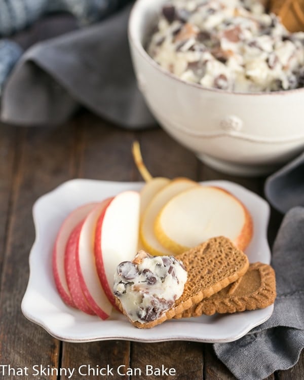 Chocolate Chip Cookie Dough Dip on a square white plate with cookies, apple and pear slices.