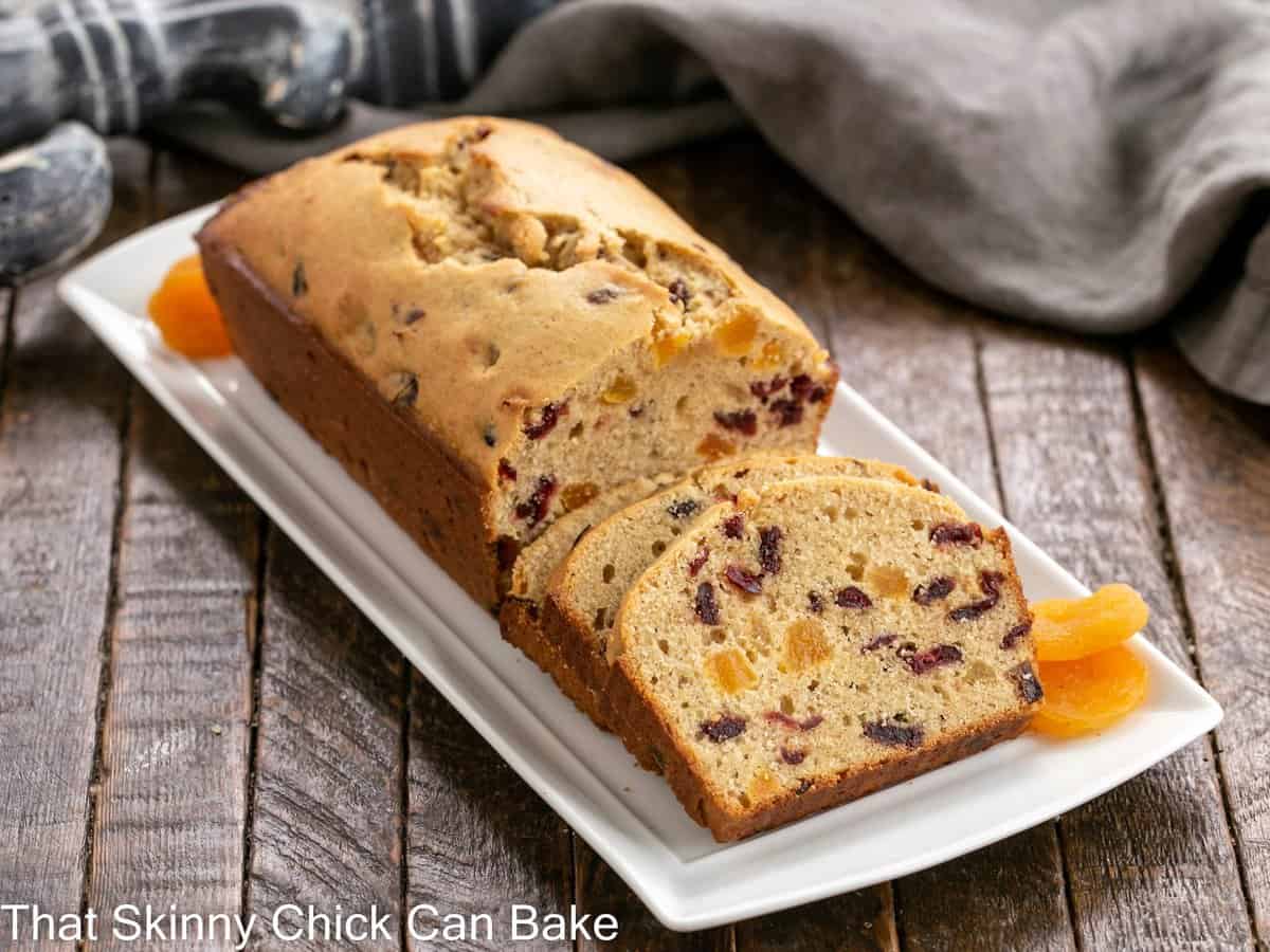 Cranberry Apricot Bread on a white tray with dried apricot garnish.