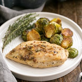 Mustard Maple Chicken Breast on a white dinner plate with Brussels sprouts