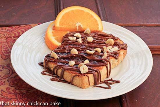 Nutella Tartine on a white plate with an orange slice