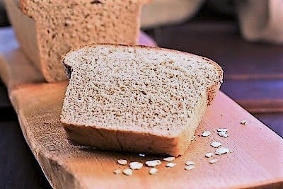 Slice of honey oat bread on a cutting board