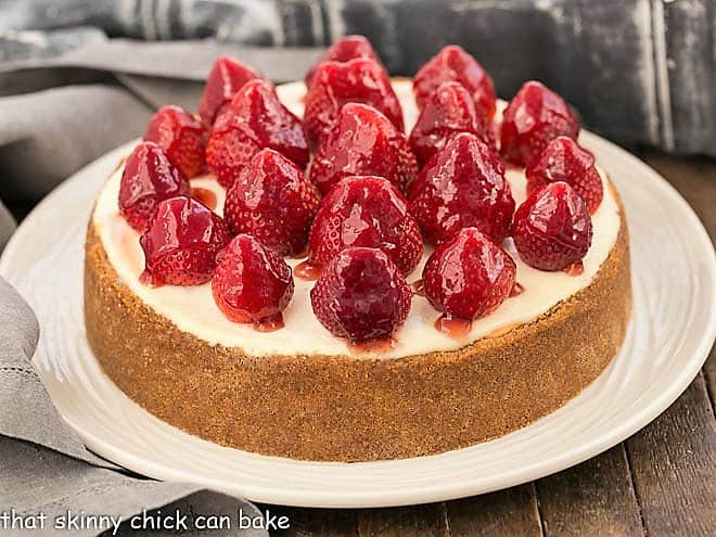 Strawberry Topped Cheesecake on a white ceramic serving plate.