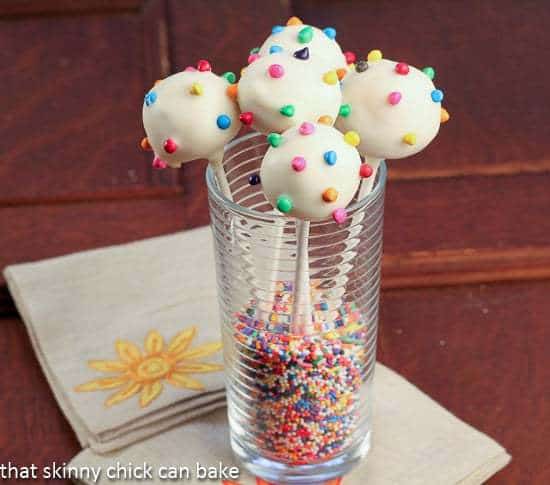 White Chocolate Dipped Cheesecake Pops in a tall glass