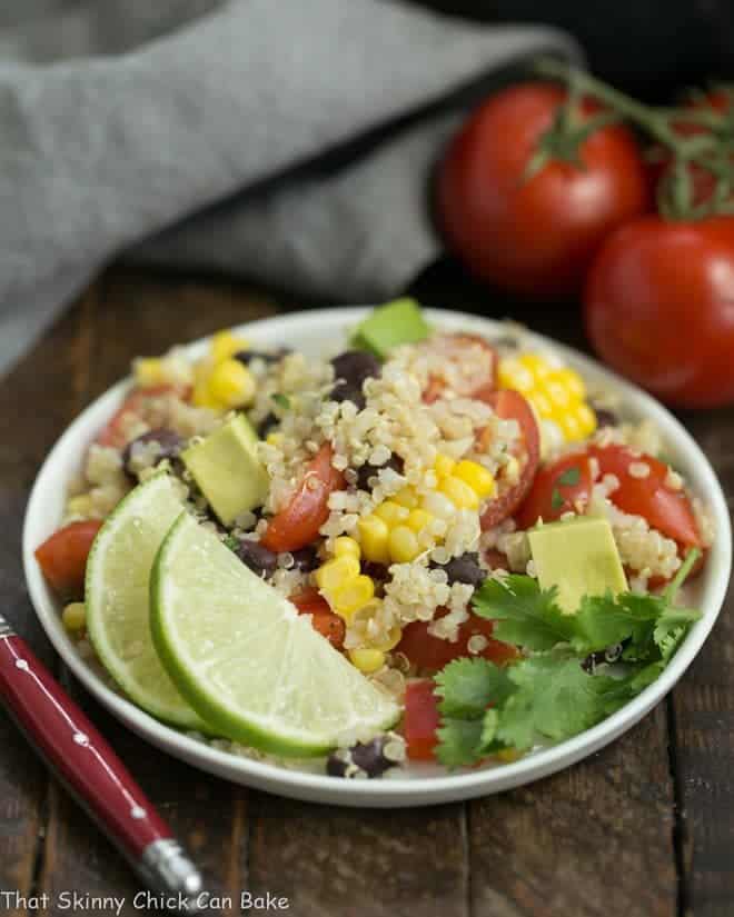 Quinoa Black Bean Salad with Lime Cumin Vinaigrette on a small white plate with a lime garnish