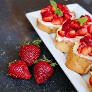 tray of strawberry crostini with 3 fresh berries