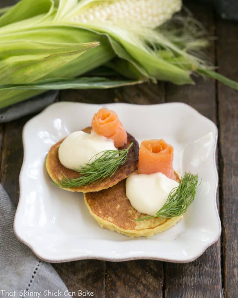 Fresh Corn Pancakes on a square plate topped with salmon and dill