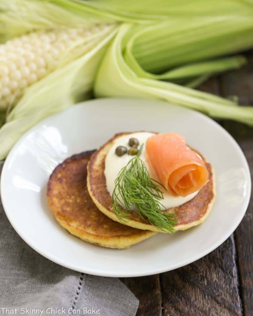 Savory Corn Cakes on a round white plate with toppings