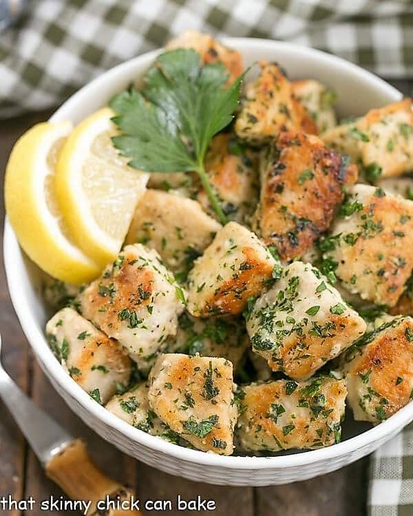 Chicken with Garlic and Parsley with lemon slices in a white bowl.