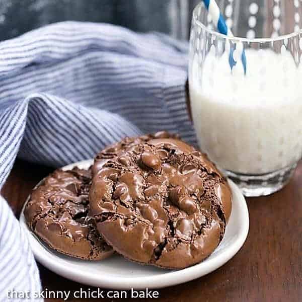 Flourless Chocolate Cookies on a small oval plate with a glass of milk.