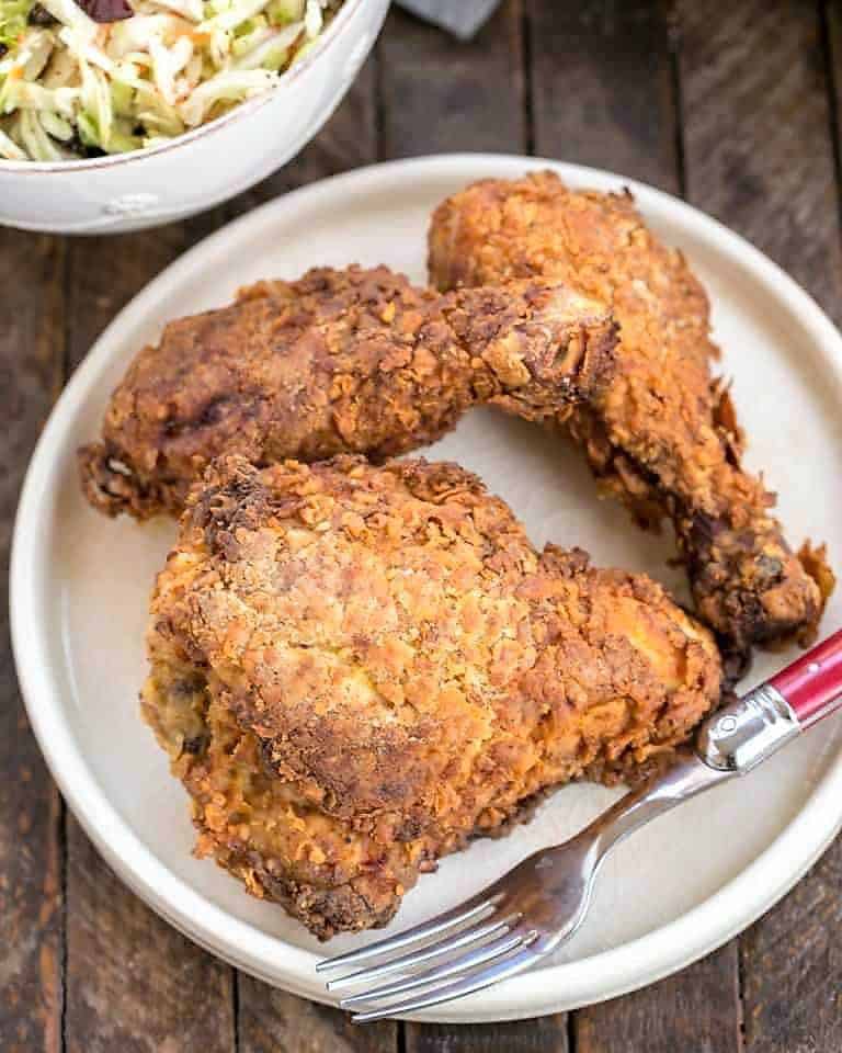 Easy Southern Fried Chicken on a white plate with a red handle fork.