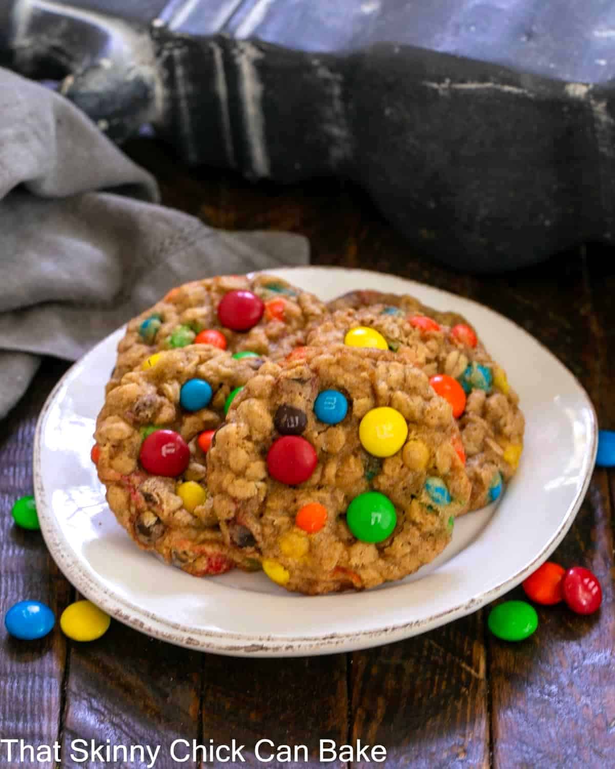4 M & M cookies on a round white plate.
