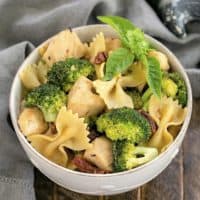 Overhead view of Chicken with Broccoli, Sun-dried Tomatoes and Bow Tie Pasta in a white ceramic bowl