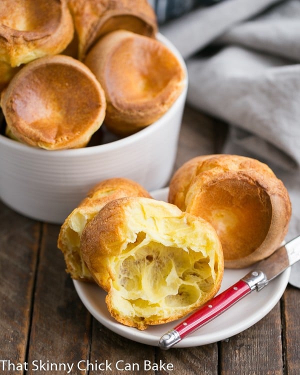 Perfect Popovers on a white plate with a smail red handled knife.