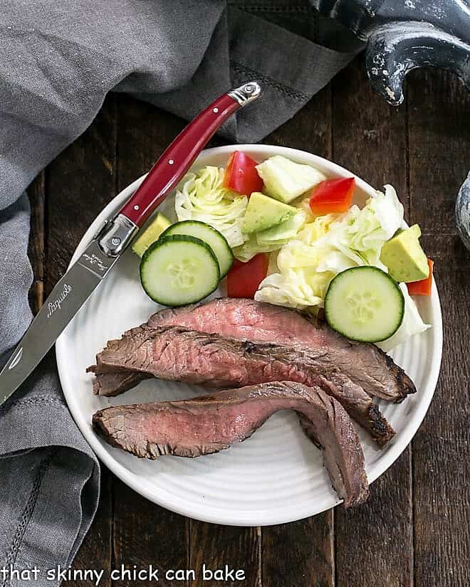 Soy, Orange Juice, Red Wine Marinade - A versatile 3-ingredient marinade that's perfect for flank steak, chicken thighs, shrimp and more! Flank steak marinated in a Soy, Orange Juice, Red Wine Marinade sliced on a round white plate.