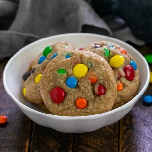 Brown butter M&M cookies in a shallow white bowl