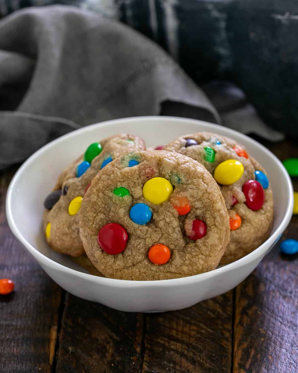 Small white  bowl of M&M Cookies.