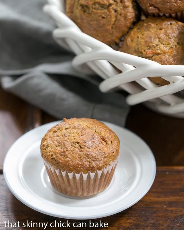 Buttermilk Bran Muffins in a white basket with a single muffin in the foreground