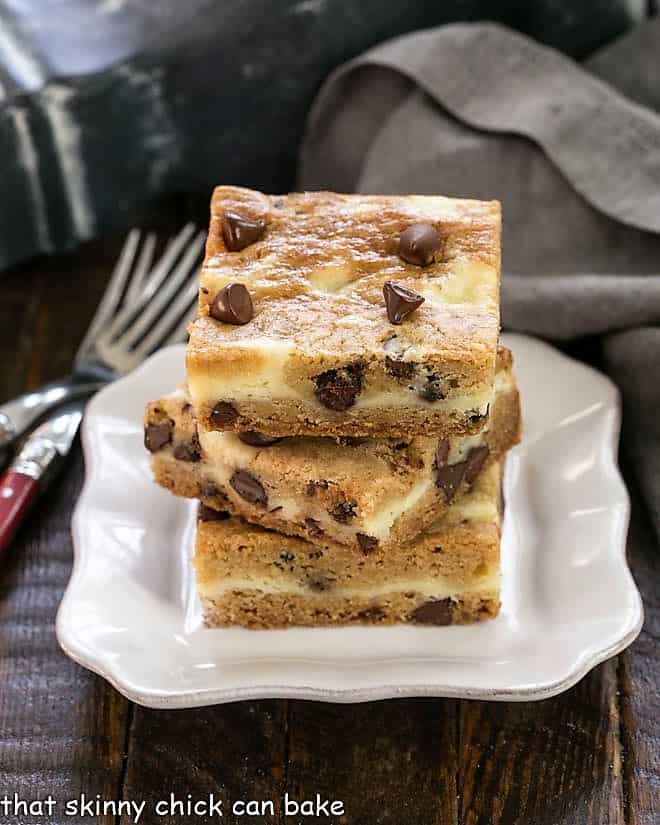 3 Cheesecake Filled Chocolate Chip Bars stacked on a square white plate