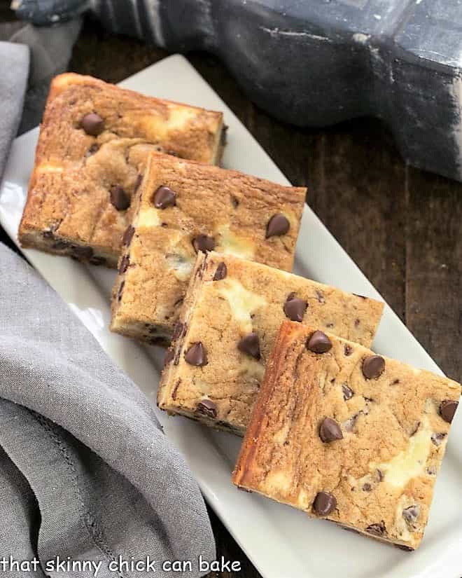 Chocolate chip cheesecake bars viewed from above on a white platter