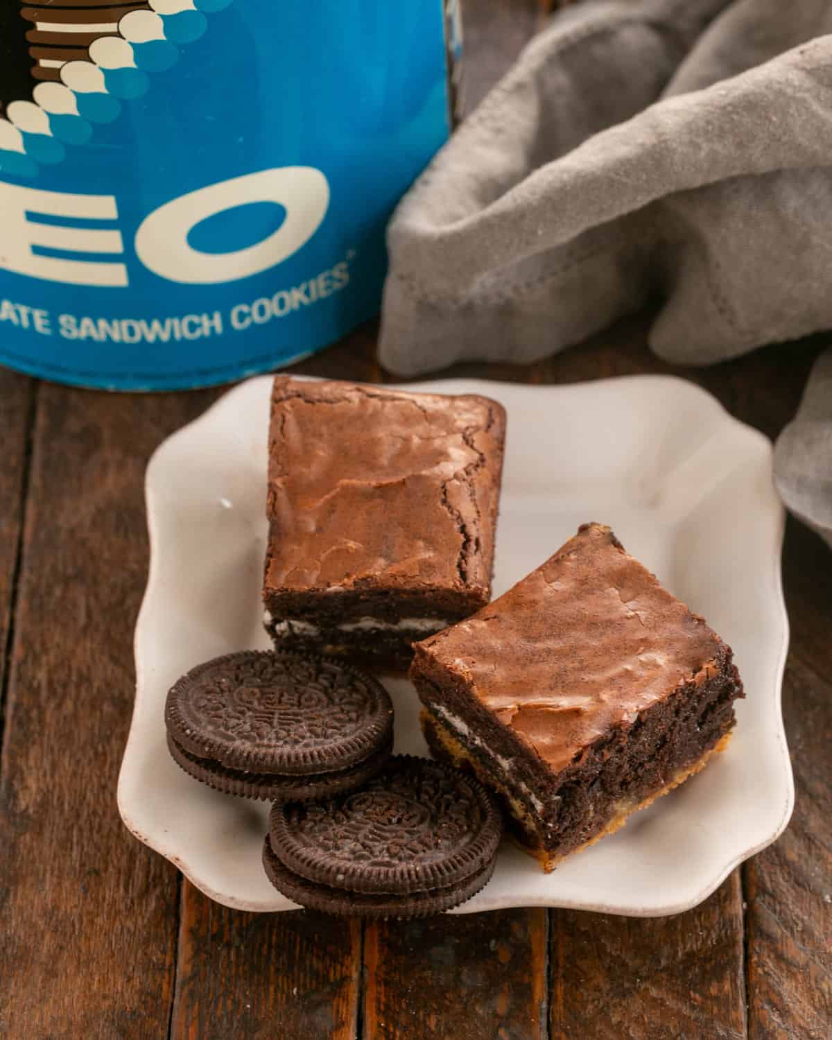 2 Oreo Chocolate Chip Brownies on a white dessert plate with 2 Oreos.