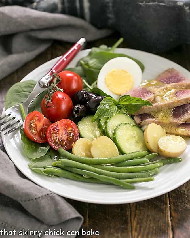 Ahi Tuna Salade Niçoise on a white salad plate with a red handled fork