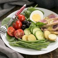 Ahi Tuna Salade Niçoise on a white salad plate with a red handled fork