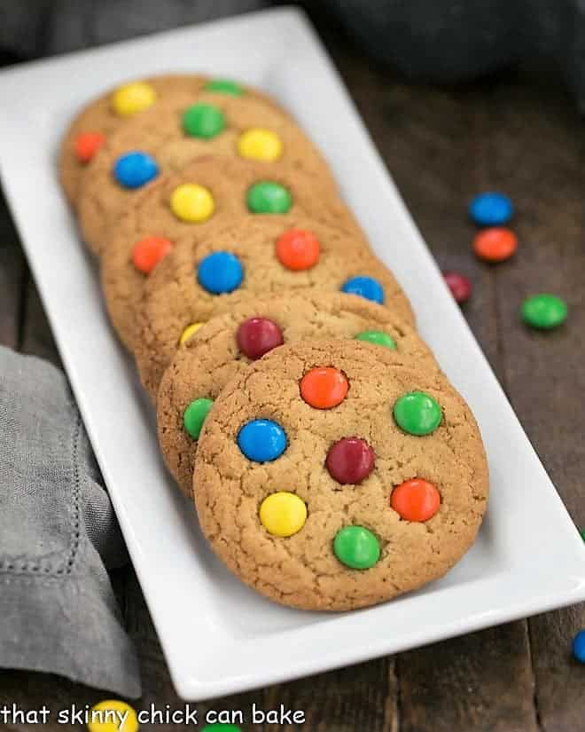 Classic M & M Cookies lined up on a white rectangular tray.