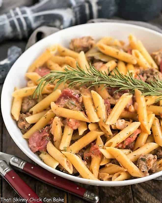 Creamy Italian Sausage Pasta Recipe - Easy Italian skillet pasta with tomatoes, rosemary, Parmesan and cream Creamy Italian Sausage Pasta in a white serving dish.