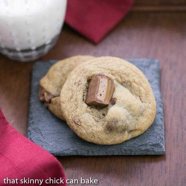 Two Milky Way Cookies on a grey stone coaster on a wooden table. 