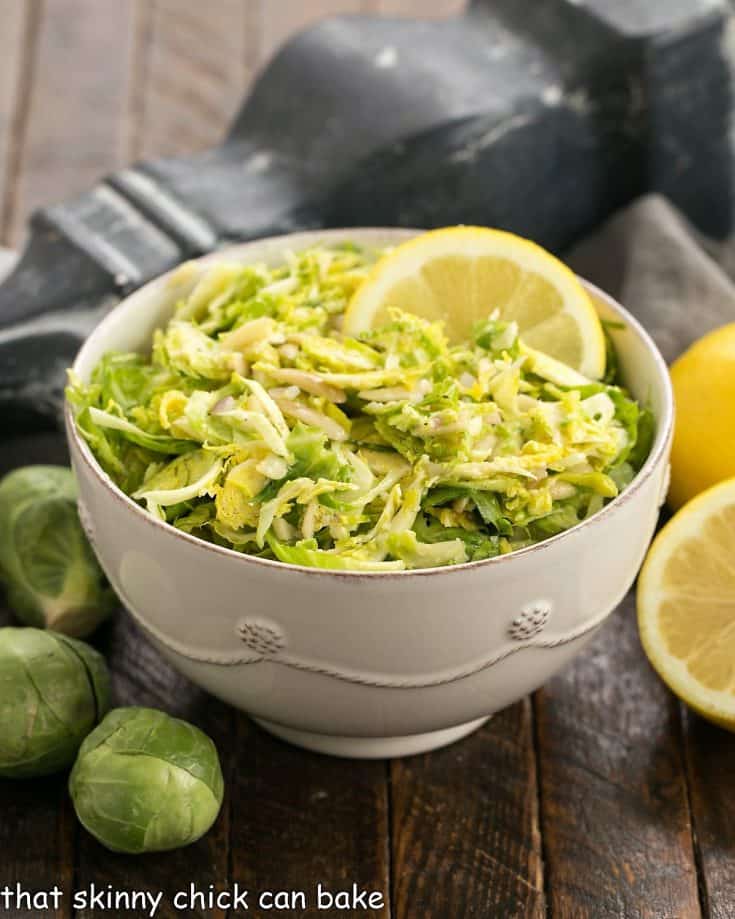 Side view of bowl of brussels sprouts salad in a white ceramic bowl