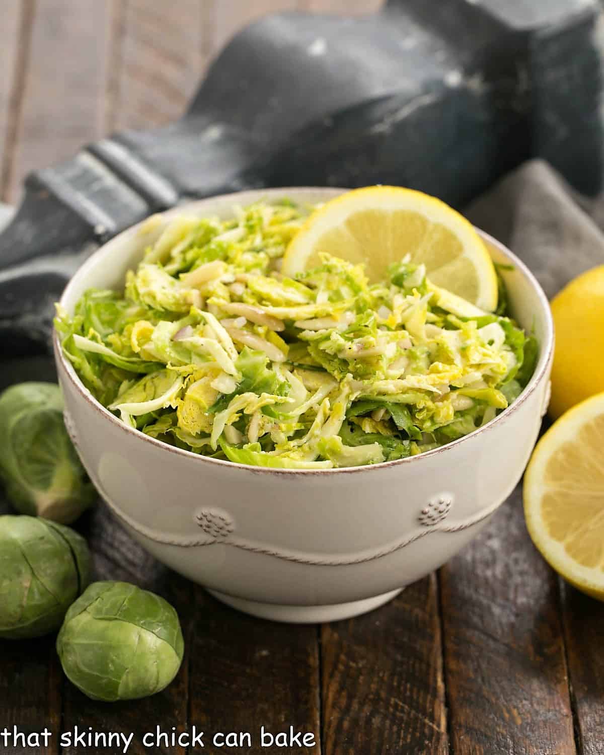 Side view of bowl of brussels sprouts salad in a white ceramic bowl.