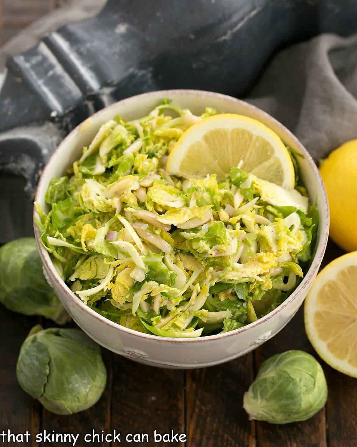 Shaved Brussels sprouts salad in a white serving bowl.