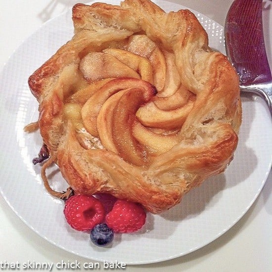 Apple Topped Baked Brie en Croute on a white serving plate