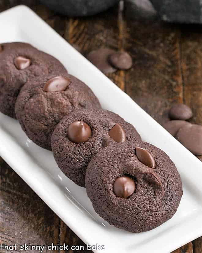 4 chocolate cookie bites on a narrow white ceramic tray.