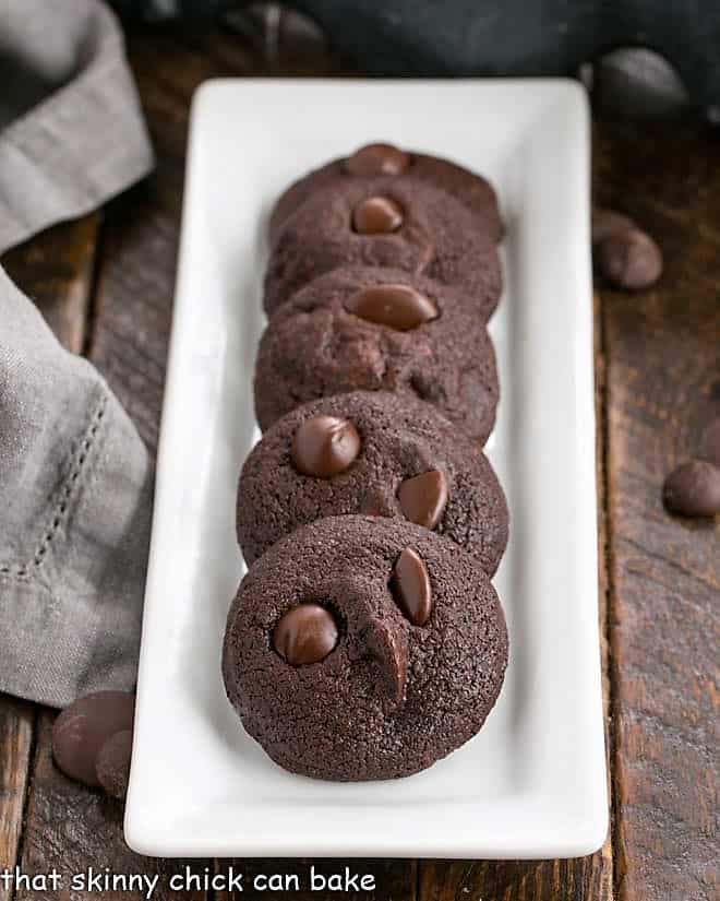 Chocolate Chocolate chip cookies lined up on a narrow white tray.