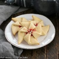 3 Poinsettia Cookies on a small white dessert plate