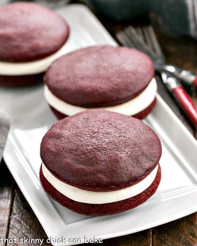 Red velvet whoopie pies on a white serving tray.