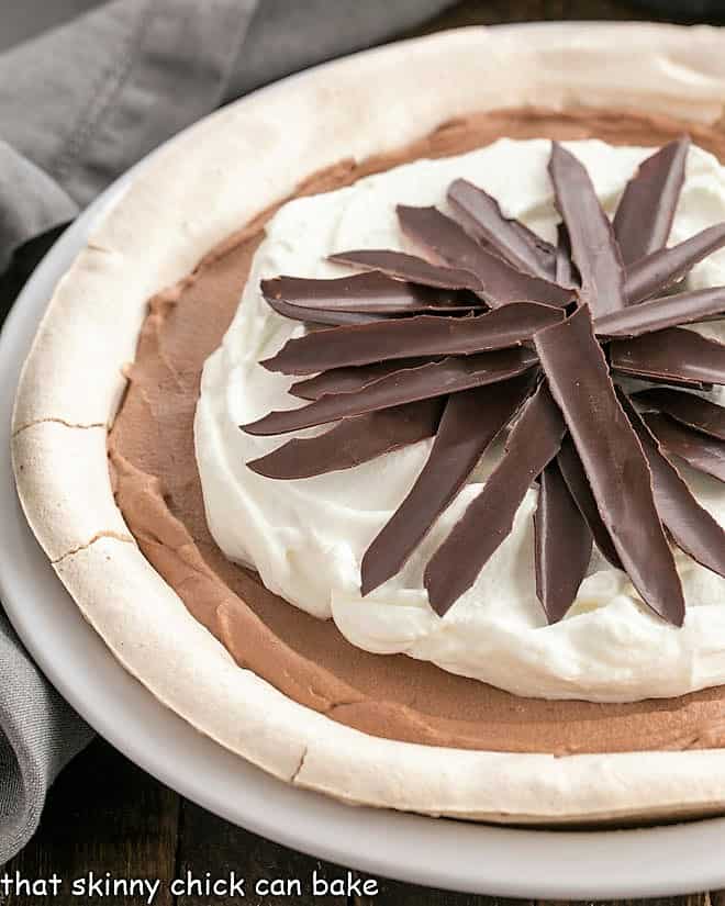 Chocolate Angel Pie - a melt in your mouth chocolate pie with a meringue crust Close up of Chocolate Angel Pie in a white ceramic pie plate.
