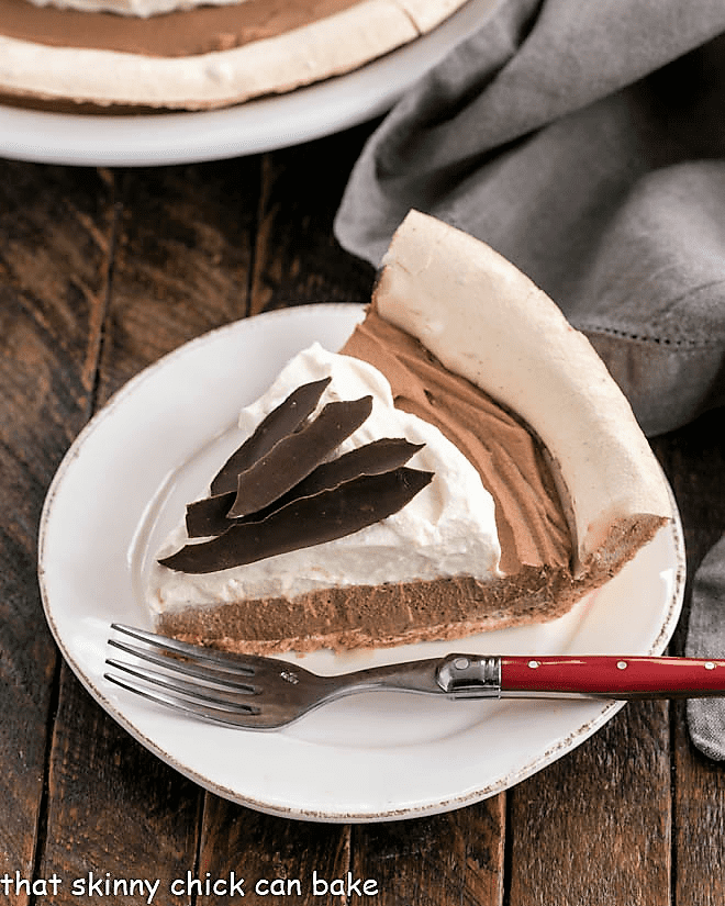 Chocolate Cream Pie Recipe - a melt in your mouth chocolate pie with a meringue crust Slice of Chocolate Angel Pie on a white plate.