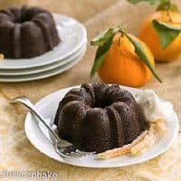 Mini Gingerbread Bundt Cakes on plates with candied orange peel