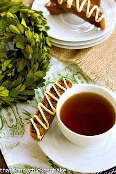 Gingerbread Biscotti on a stack of saucers and with a cup of tea