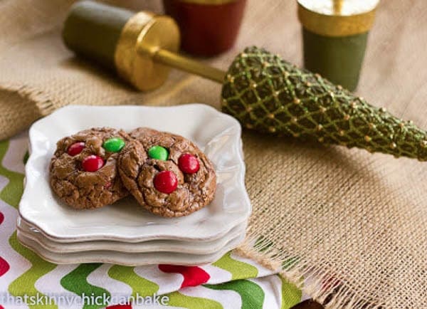 Holiday Truffle Cookies - chewy rich chocolate cookies studded with red and green M & M's for a festive Christmas treat! Holiday Truffle Cookies on a stack of white plates with Christmas decor
